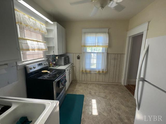 2107 SE Kenwood Blvd, Roanoke, VA 24013 - kitchen featuring freestanding refrigerator, electric range, a ceiling fan, wainscoting, and open shelves