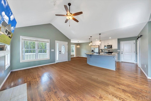 1400 Mountain Cut Rd, Appomattox, VA 24522 - unfurnished living room featuring a sink, ceiling fan with notable chandelier, wood finished floors, high vaulted ceiling, and baseboards