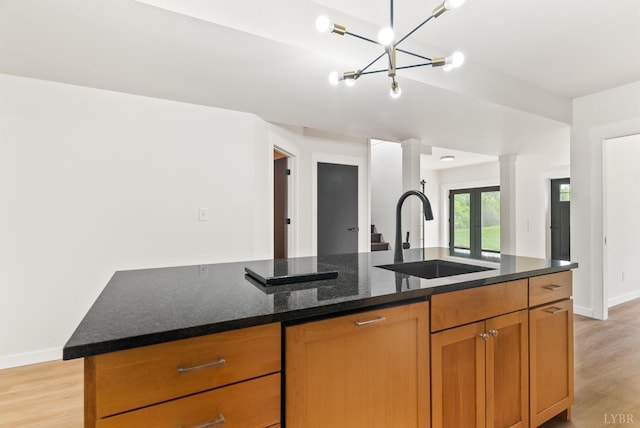1208 Rocky Branch Dr, Forest, VA 24551 - kitchen with a sink, light wood finished floors, dark stone counters, baseboards, and brown cabinetry