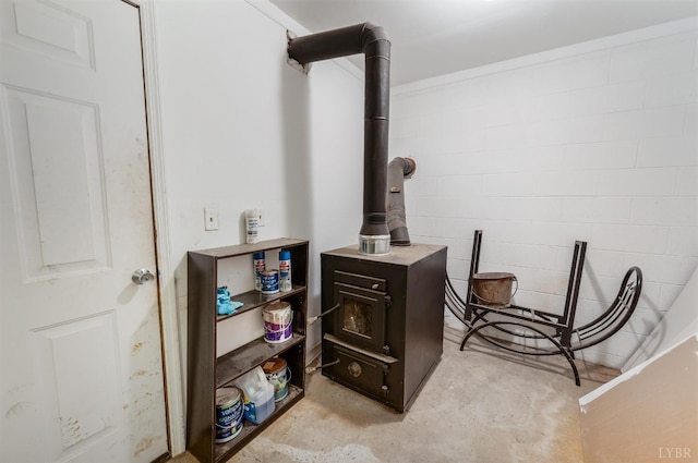 1132 Bancroft, Goode, VA 24556 - interior details featuring a wood stove, concrete block wall, and unfinished concrete flooring