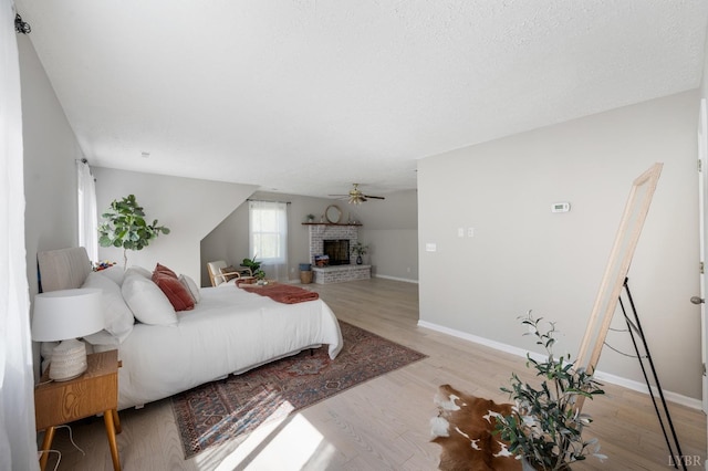 1132 Bancroft, Goode, VA 24556 - bedroom with a brick fireplace, baseboards, vaulted ceiling, and light wood-style flooring