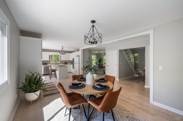1132 Bancroft, Goode, VA 24556 - dining space with baseboards, light wood finished floors, stairs, and a chandelier