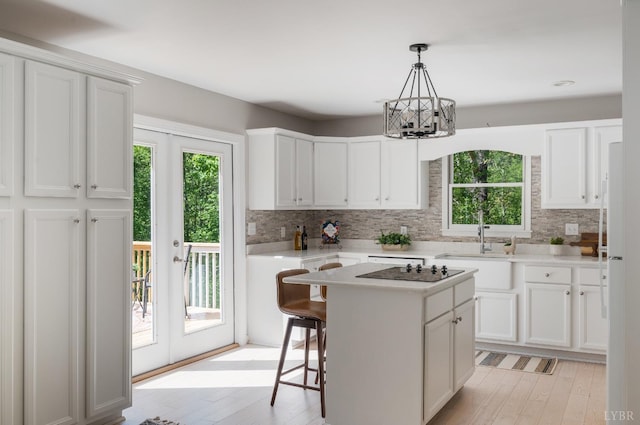 1132 Bancroft, Goode, VA 24556 - kitchen with white cabinets, a chandelier, decorative backsplash, and a sink