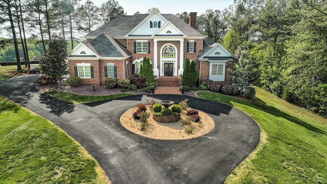 107 Emory Way, Amherst, VA 24521 - neoclassical home with a front lawn, brick siding, a chimney, and curved driveway