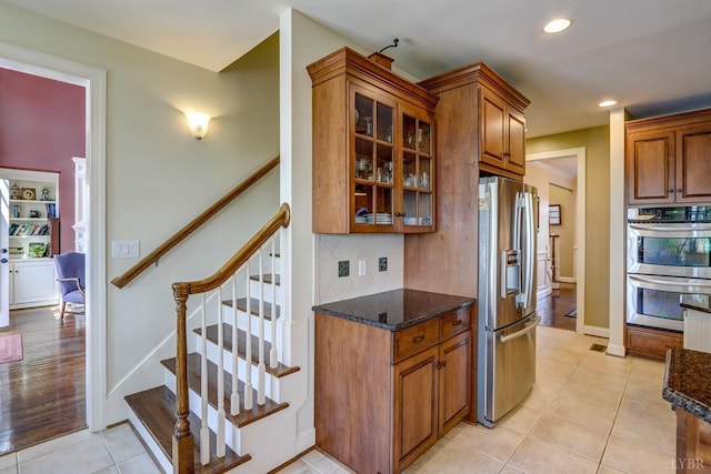 107 Emory Way, Amherst, VA 24521 - kitchen with stainless steel appliances, dark stone countertops, glass insert cabinets, and brown cabinets
