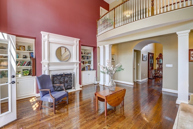 107 Emory Way, Amherst, VA 24521 - living area with a fireplace, decorative columns, a towering ceiling, and wood finished floors