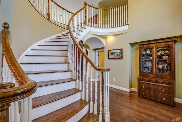 107 Emory Way, Amherst, VA 24521 - staircase featuring arched walkways, baseboards, a towering ceiling, and wood finished floors
