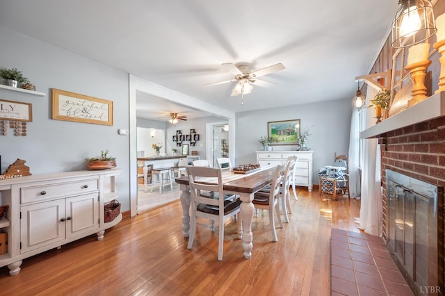 1206 Cedar Hill Dr, Lynchburg, VA 24502 - dining room with ceiling fan, light wood finished floors, and a brick fireplace