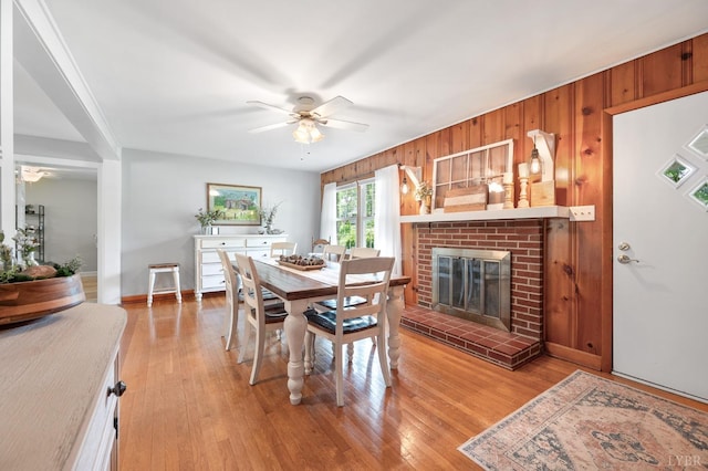 1206 Cedar Hill Dr, Lynchburg, VA 24502 - dining area featuring ceiling fan, light wood-type flooring, a brick fireplace, and wooden walls
