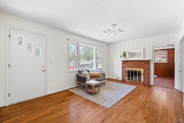 4600 Greenwood Dr, Lynchburg, VA 24502 - living room featuring wood finished floors, a chandelier, a brick fireplace, and baseboards