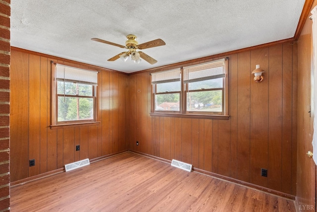 4600 Greenwood Dr, Lynchburg, VA 24502 - spare room featuring light wood-type flooring, baseboards, ceiling fan, a textured ceiling, and wood walls