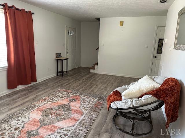 202 Rustwood Ct, Rustburg, VA 24588 - living area featuring wood finished floors, baseboards, a textured ceiling, and stairway