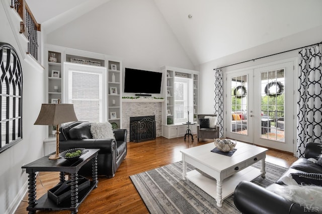 1205 Bradford Crossing Pl, Goode, VA 24556 - living area with french doors, a fireplace, built in shelves, wood finished floors, and high vaulted ceiling