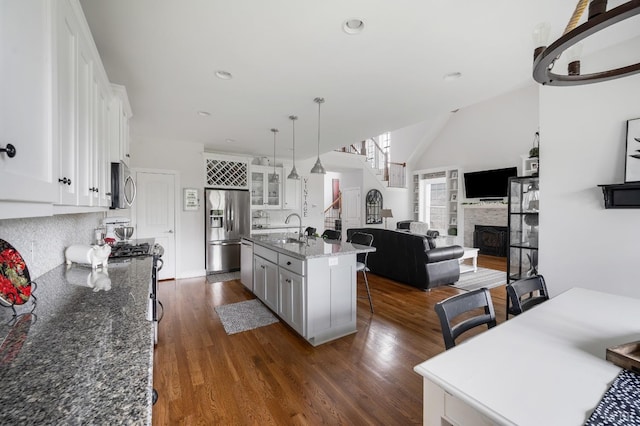1205 Bradford Crossing Pl, Goode, VA 24556 - kitchen with white cabinets, a breakfast bar, a sink, stainless steel appliances, and dark wood-style floors