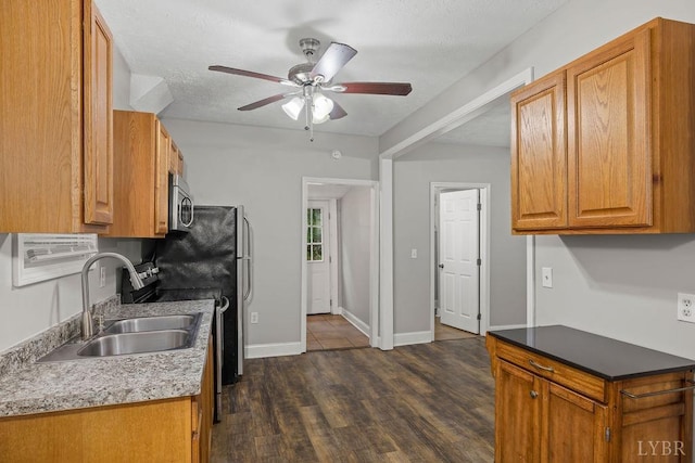 609 Jackson St, Lynchburg, VA 24504 - kitchen with a sink, a ceiling fan, appliances with stainless steel finishes, dark wood-type flooring, and brown cabinets