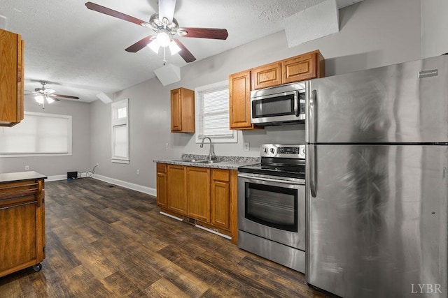 609 Jackson St, Lynchburg, VA 24504 - kitchen with appliances with stainless steel finishes, a sink, a ceiling fan, dark wood finished floors, and brown cabinetry
