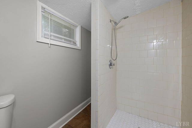 609 Jackson St, Lynchburg, VA 24504 - bathroom featuring a tile shower, toilet, a textured ceiling, and baseboards
