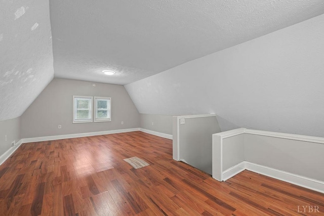 609 Jackson St, Lynchburg, VA 24504 - bonus room with a textured ceiling, lofted ceiling, wood finished floors, and baseboards
