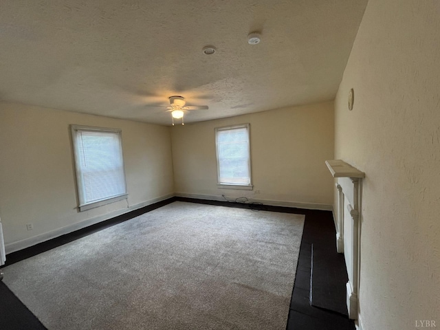 1603 Taylor St, Lynchburg, VA 24504 - unfurnished living room featuring dark carpet, ceiling fan, baseboards, a textured ceiling, and a textured wall