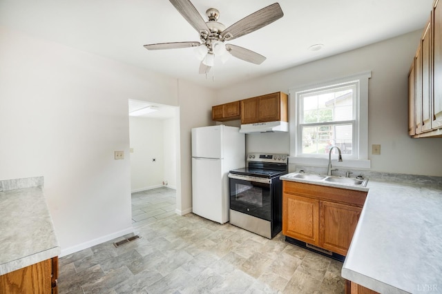 730 Stuart St, Lynchburg, VA 24501 - kitchen featuring stainless steel range with electric stovetop, freestanding refrigerator, under cabinet range hood, a sink, and brown cabinetry
