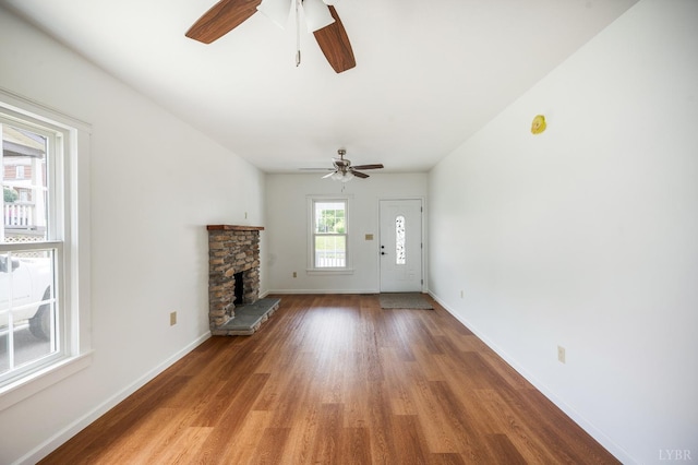 730 Stuart St, Lynchburg, VA 24501 - unfurnished living room with ceiling fan, light wood-style flooring, a stone fireplace, and baseboards