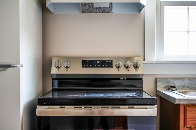 730 Stuart St, Lynchburg, VA 24501 - kitchen view of electric range, extractor fan, and freestanding refrigerator