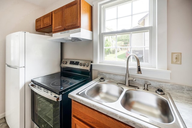 730 Stuart St, Lynchburg, VA 24501 - kitchen with electric stove, under cabinet range hood, brown cabinets, a sink, and light countertops
