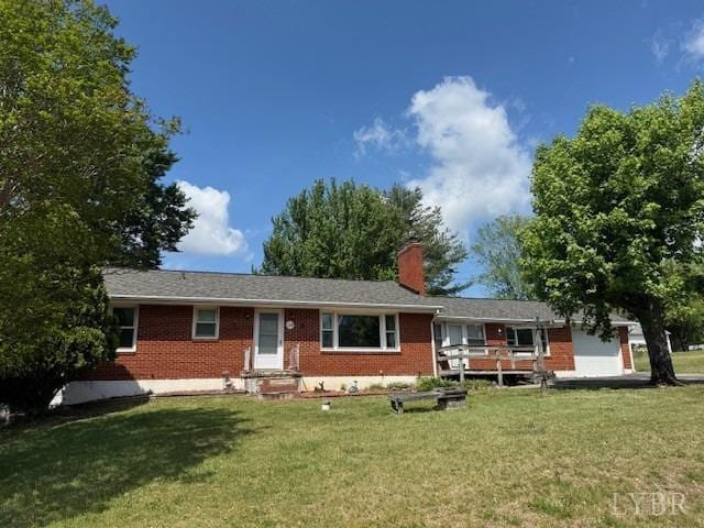 single story home featuring a chimney, a front lawn, and brick siding