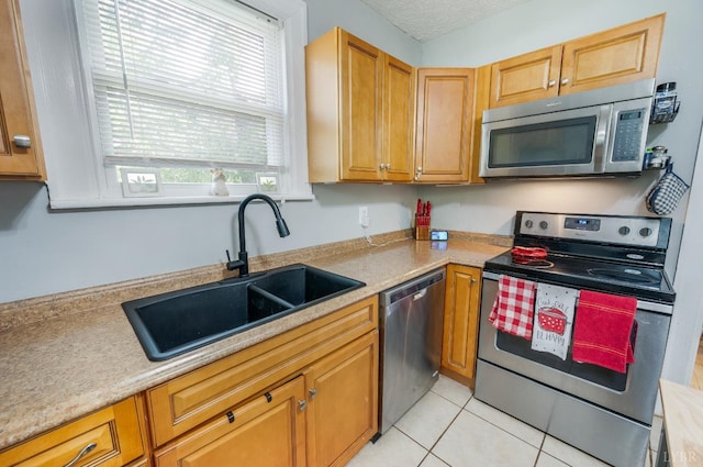 4205 Tremont, Lynchburg, VA 24502 - kitchen featuring appliances with stainless steel finishes, a sink, light countertops, light tile patterned floors, and brown cabinetry