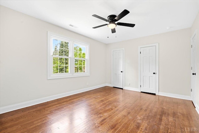 3882 Peakland Pl, Lynchburg, VA 24503 - unfurnished bedroom featuring wood finished floors, baseboards, two closets, and a ceiling fan