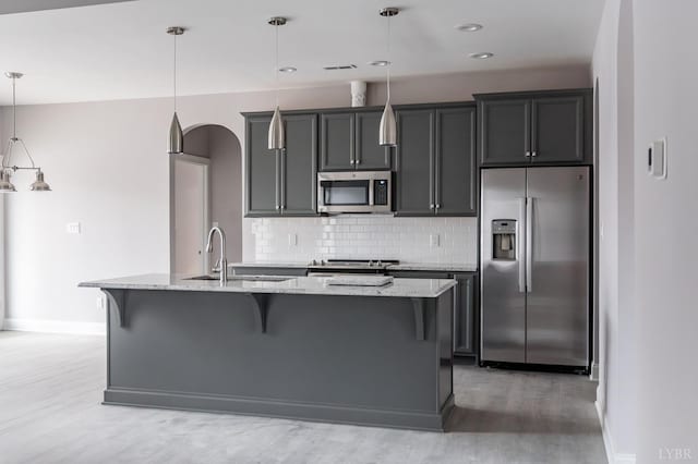 1051 Wills Way, Forest, VA 24551 - kitchen with appliances with stainless steel finishes, light wood-style flooring, a sink, baseboards, and a center island with sink