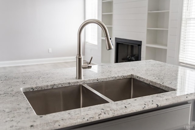 1051 Wills Way, Forest, VA 24551 - kitchen view of a sink, light stone countertops, a glass covered fireplace, and baseboards