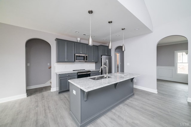 1051 Wills Way, Forest, VA 24551 - kitchen featuring appliances with stainless steel finishes, arched walkways, a breakfast bar area, light wood finished floors, and an island with sink