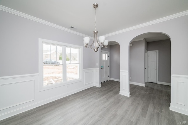 1051 Wills Way, Forest, VA 24551 - unfurnished dining area with arched walkways, wood finished floors, a wainscoted wall, a chandelier, and ornamental molding