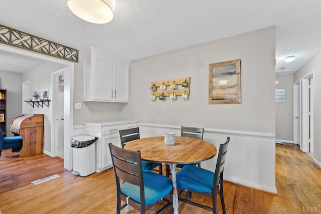 206 Simsbury Ln, Forest, VA 24551 - dining space with light wood finished floors, a textured ceiling, and baseboards