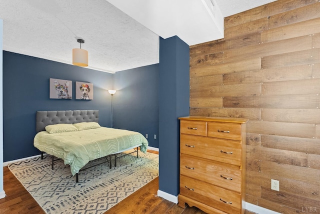 206 Simsbury Ln, Forest, VA 24551 - bedroom with a textured ceiling, dark wood-style floors, baseboards, and wooden walls