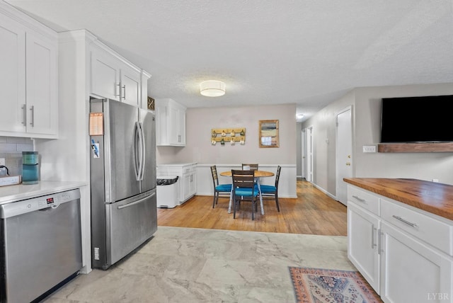 206 Simsbury Ln, Forest, VA 24551 - kitchen with appliances with stainless steel finishes, wooden counters, white cabinetry, a textured ceiling, and tasteful backsplash