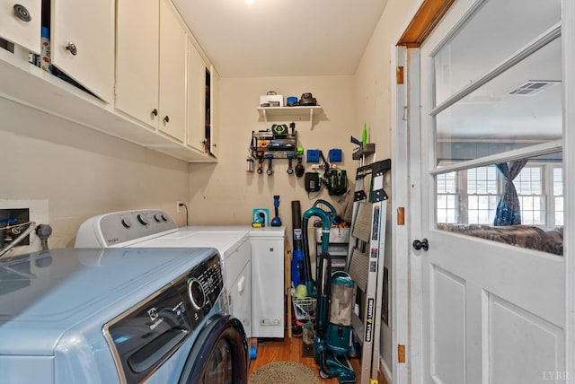 2637 Chilton Rd, Appomattox, VA 24522 - laundry area featuring washing machine and clothes dryer, cabinet space, and wood finished floors