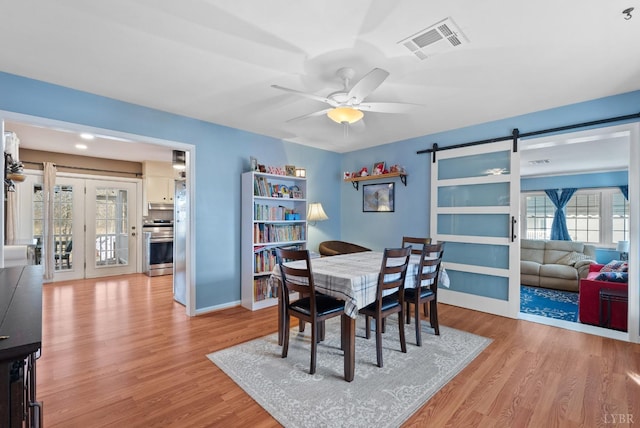 2637 Chilton Rd, Appomattox, VA 24522 - dining space featuring a barn door, wood finished floors, ceiling fan, and plenty of natural light