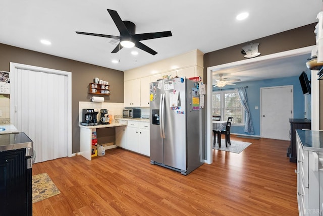 2637 Chilton Rd, Appomattox, VA 24522 - kitchen featuring appliances with stainless steel finishes, a ceiling fan, backsplash, light wood-style flooring, and white cabinetry