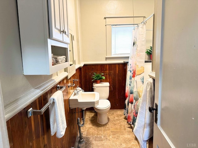 306 Oakridge Blvd, Lynchburg, VA 24502 - bathroom with stone finish flooring, a sink, toilet, wooden walls, and a shower with shower curtain