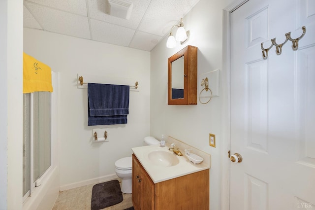 full bathroom featuring vanity, toilet, tile patterned floors, baseboards, and a drop ceiling