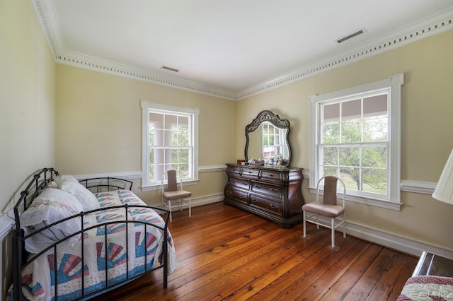 bedroom featuring visible vents, hardwood / wood-style floors, and multiple windows