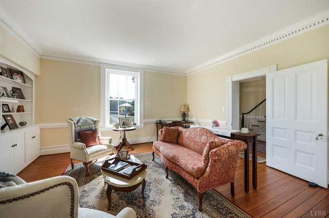 living room with stairs, baseboards, ornamental molding, and wood finished floors