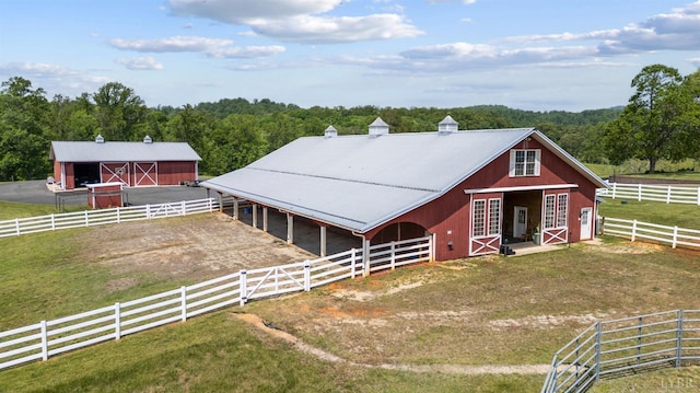 view of stable featuring a view of trees