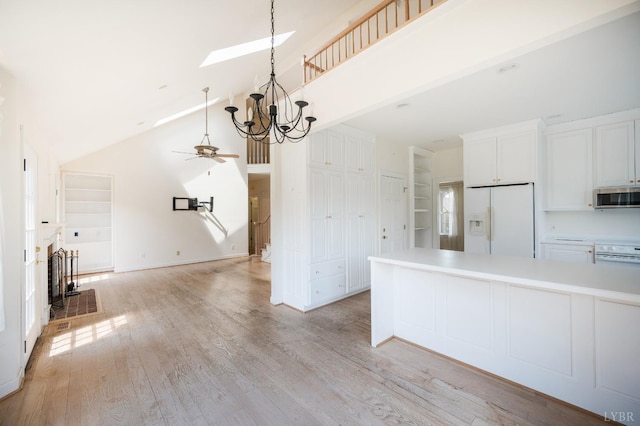 1348 Lake Shore Dr, Forest, VA 24551 - kitchen with white fridge with ice dispenser, stainless steel microwave, high vaulted ceiling, white cabinets, and light countertops