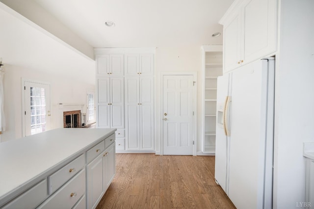 1348 Lake Shore Dr, Forest, VA 24551 - kitchen featuring white fridge with ice dispenser, light wood finished floors, white cabinets, and light countertops