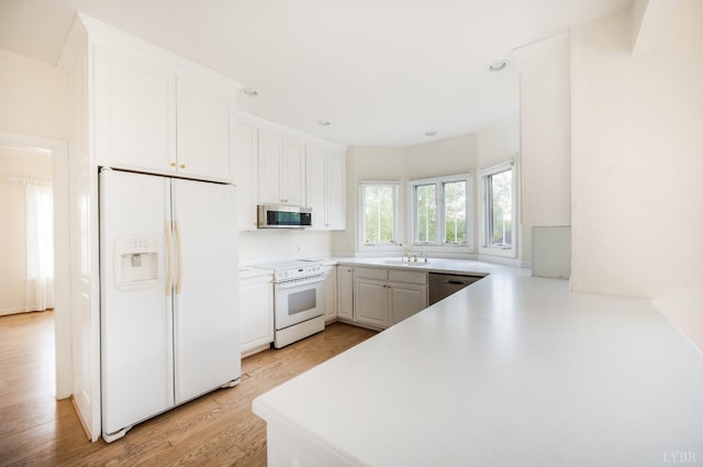 1348 Lake Shore Dr, Forest, VA 24551 - kitchen with stainless steel appliances, light wood finished floors, white cabinets, a sink, and light countertops