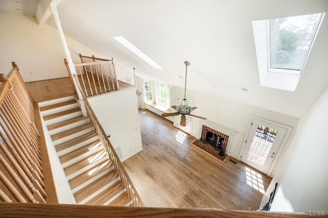 1348 Lake Shore Dr, Forest, VA 24551 - stairs featuring a skylight, wood finished floors, high vaulted ceiling, and a brick fireplace