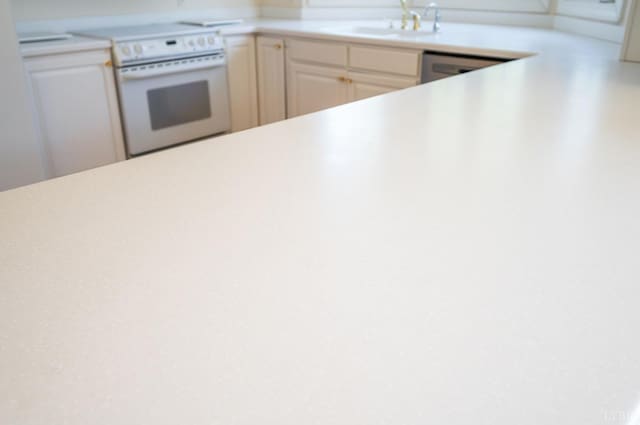 1348 Lake Shore Dr, Forest, VA 24551 - kitchen with white range with electric cooktop, light countertops, a sink, and white cabinetry